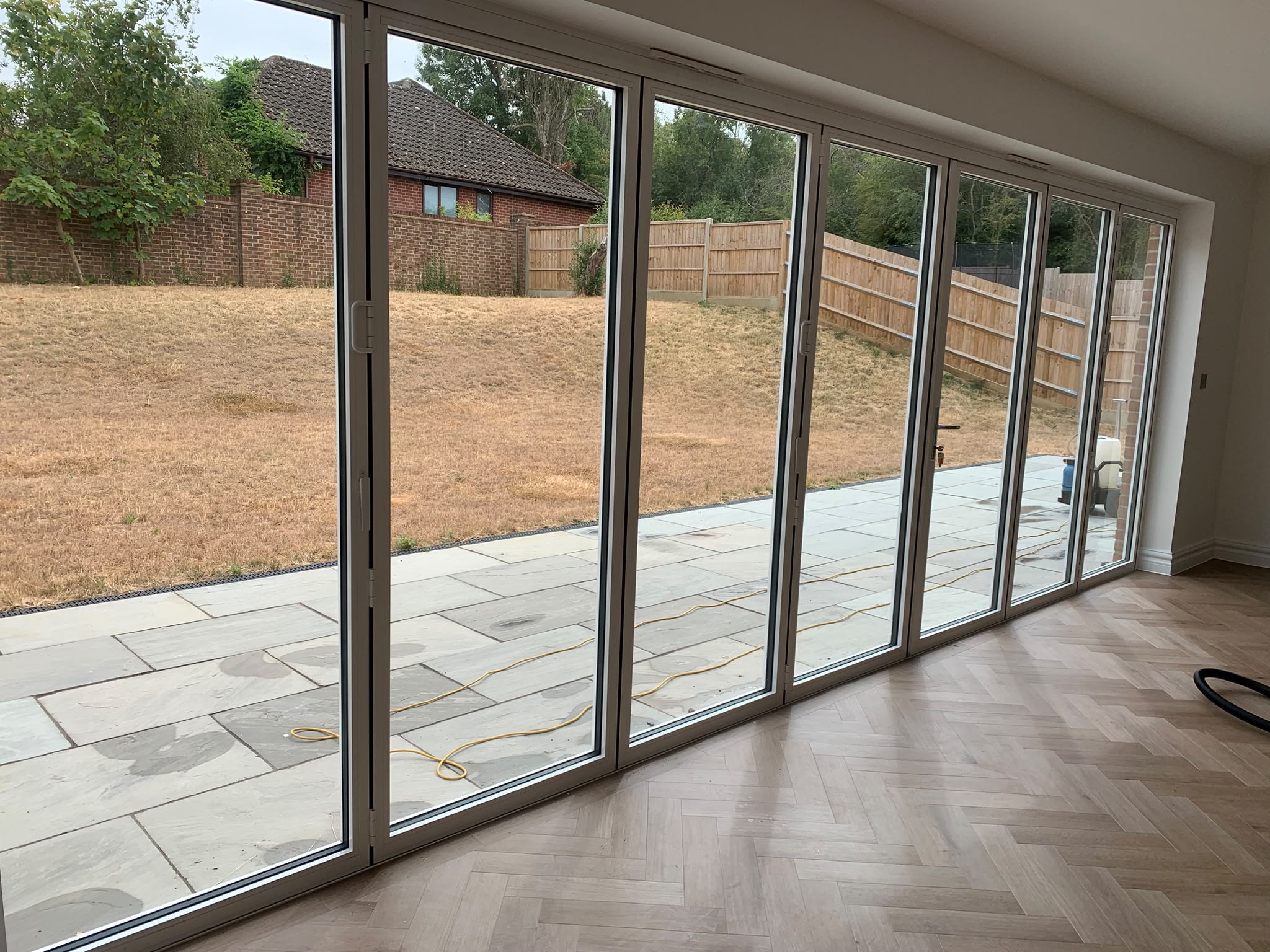New build interior with bifold doors and herringbone floor after builders clean