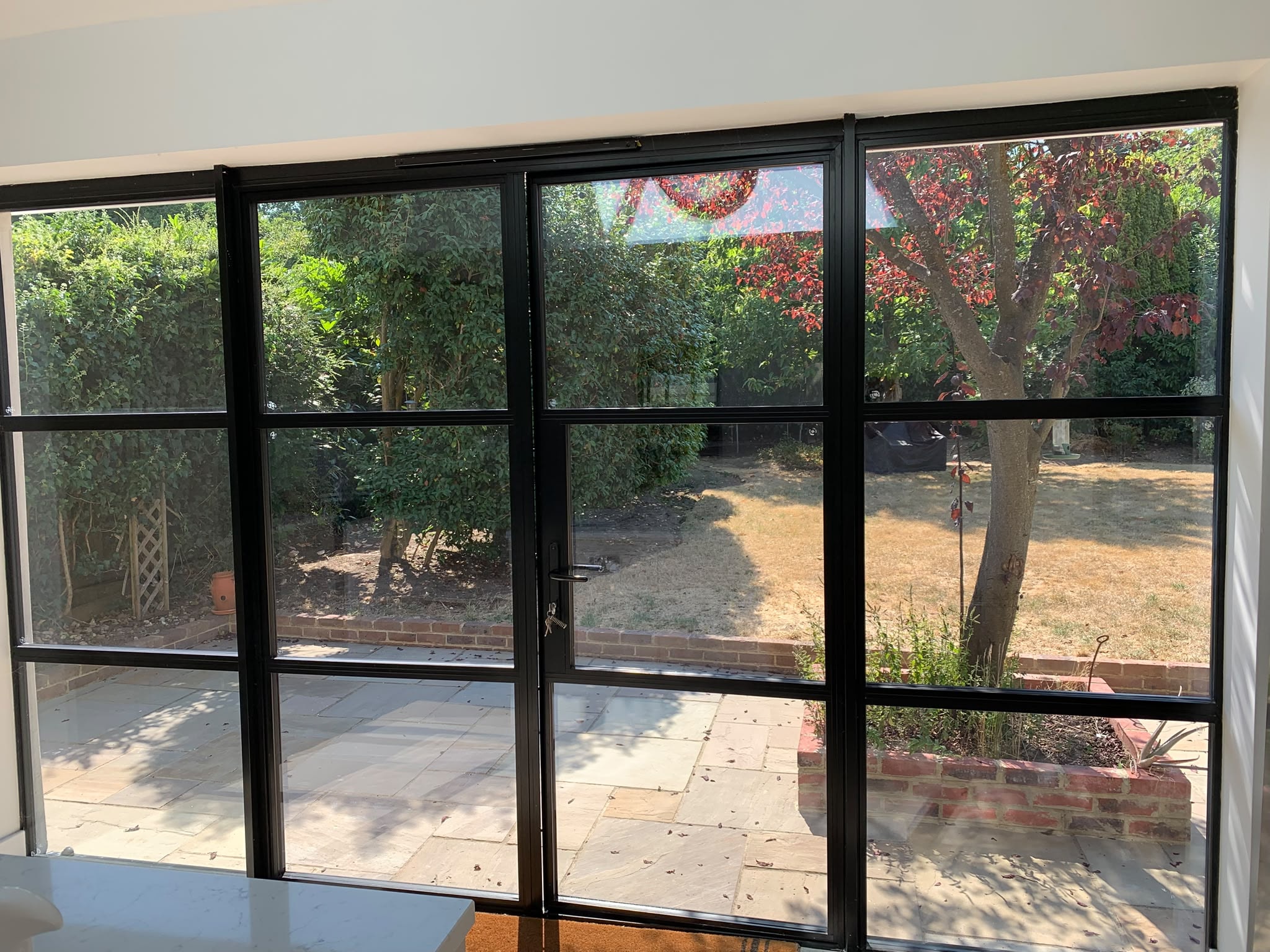 Black-frame crittall-style windows and doors cleaned to streak-free finish after new build