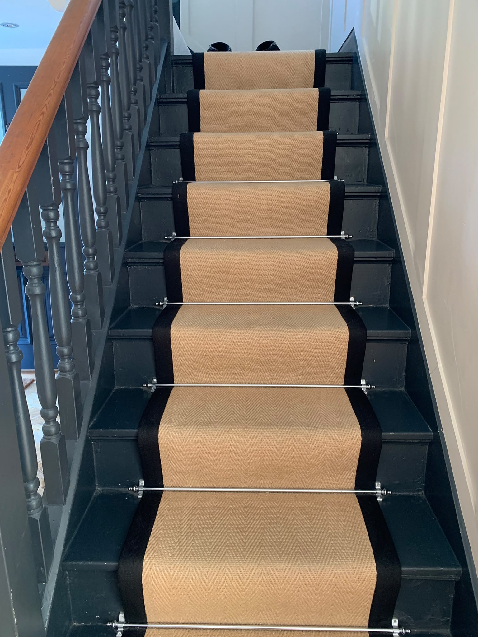 Black staircase with herringbone carpet runner professionally cleaned — AM 2 PM