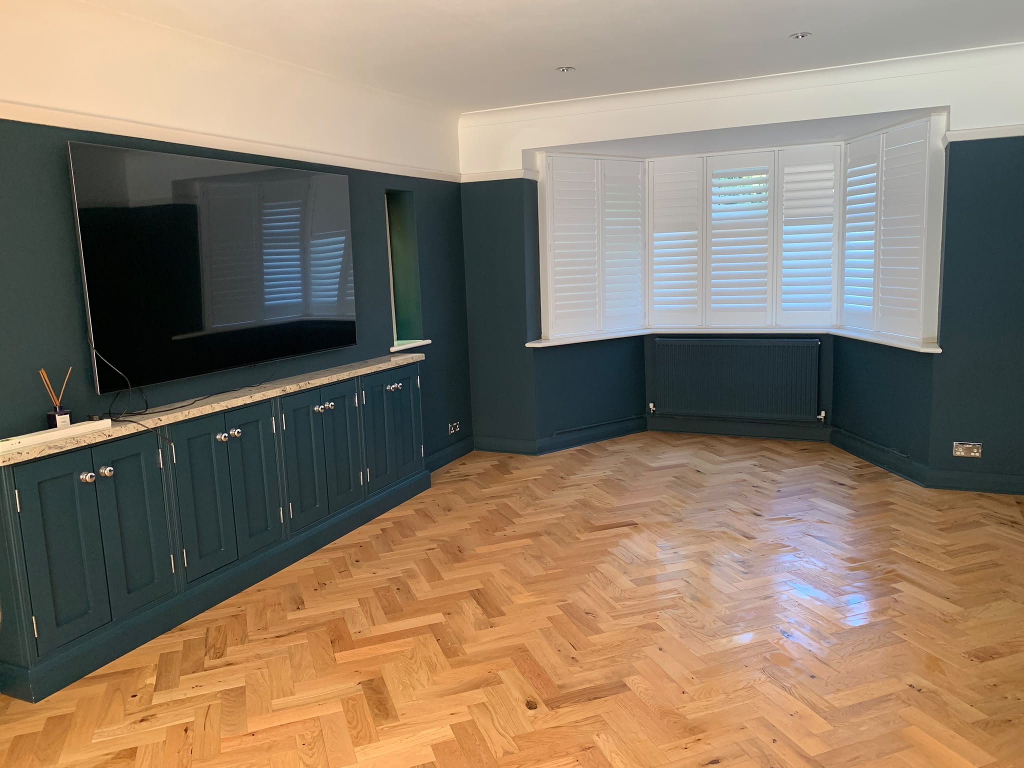 Teal living room with herringbone parquet floor before deep clean — AM 2 PM Cleaning Services