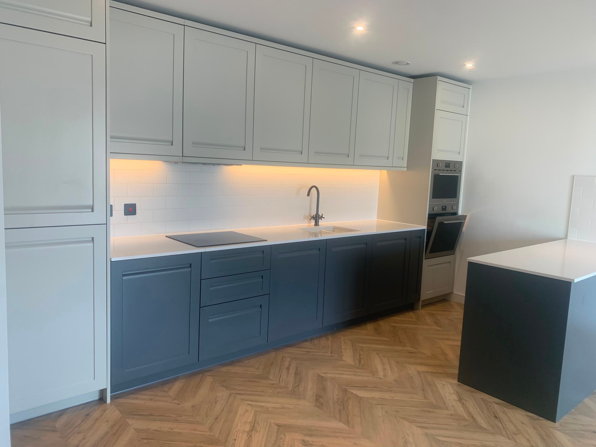 Spotless kitchen with blue-grey shaker cabinets after end of tenancy deep clean