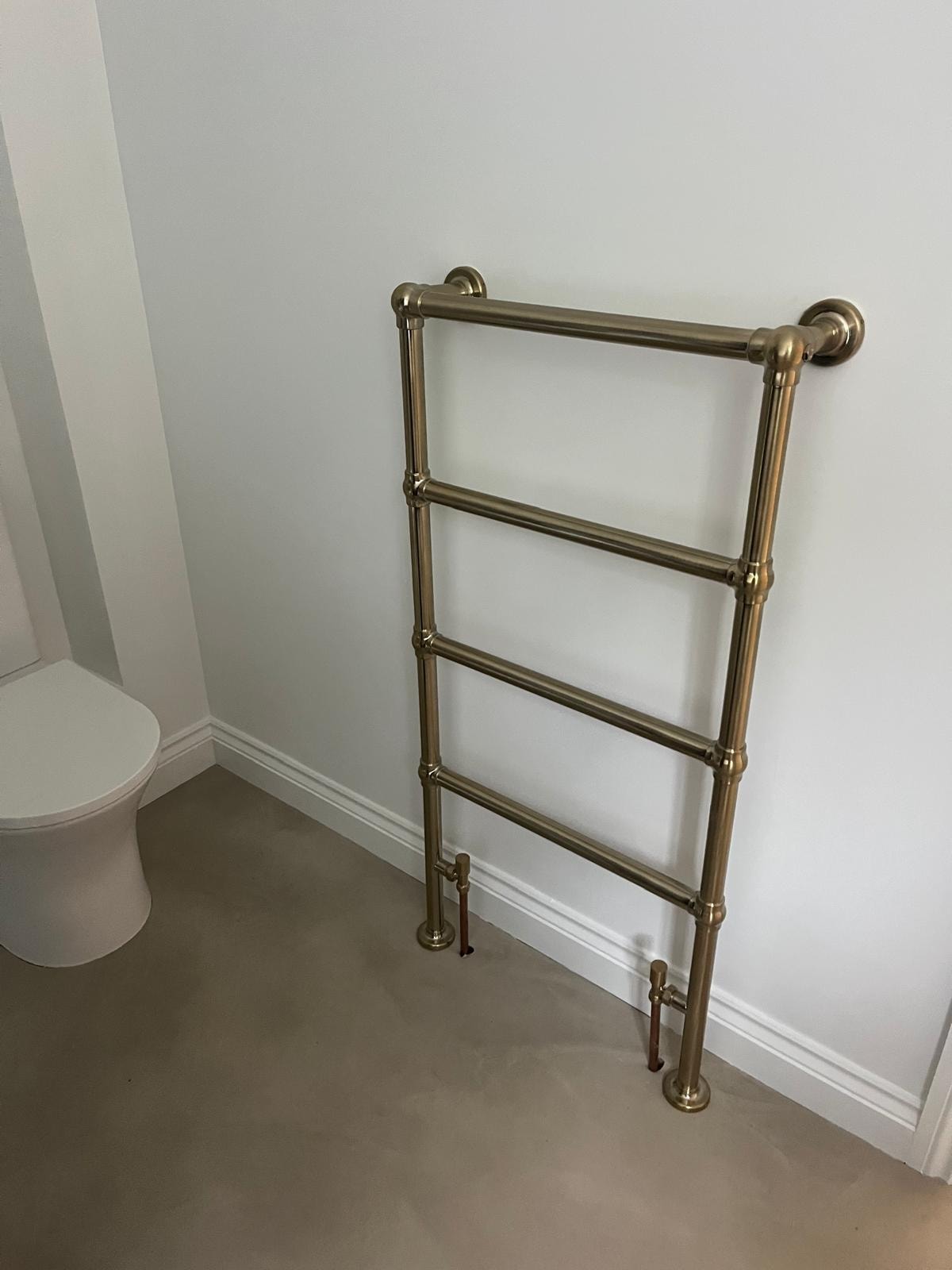 Brass heated towel rail installed in newly renovated bathroom — Surrey